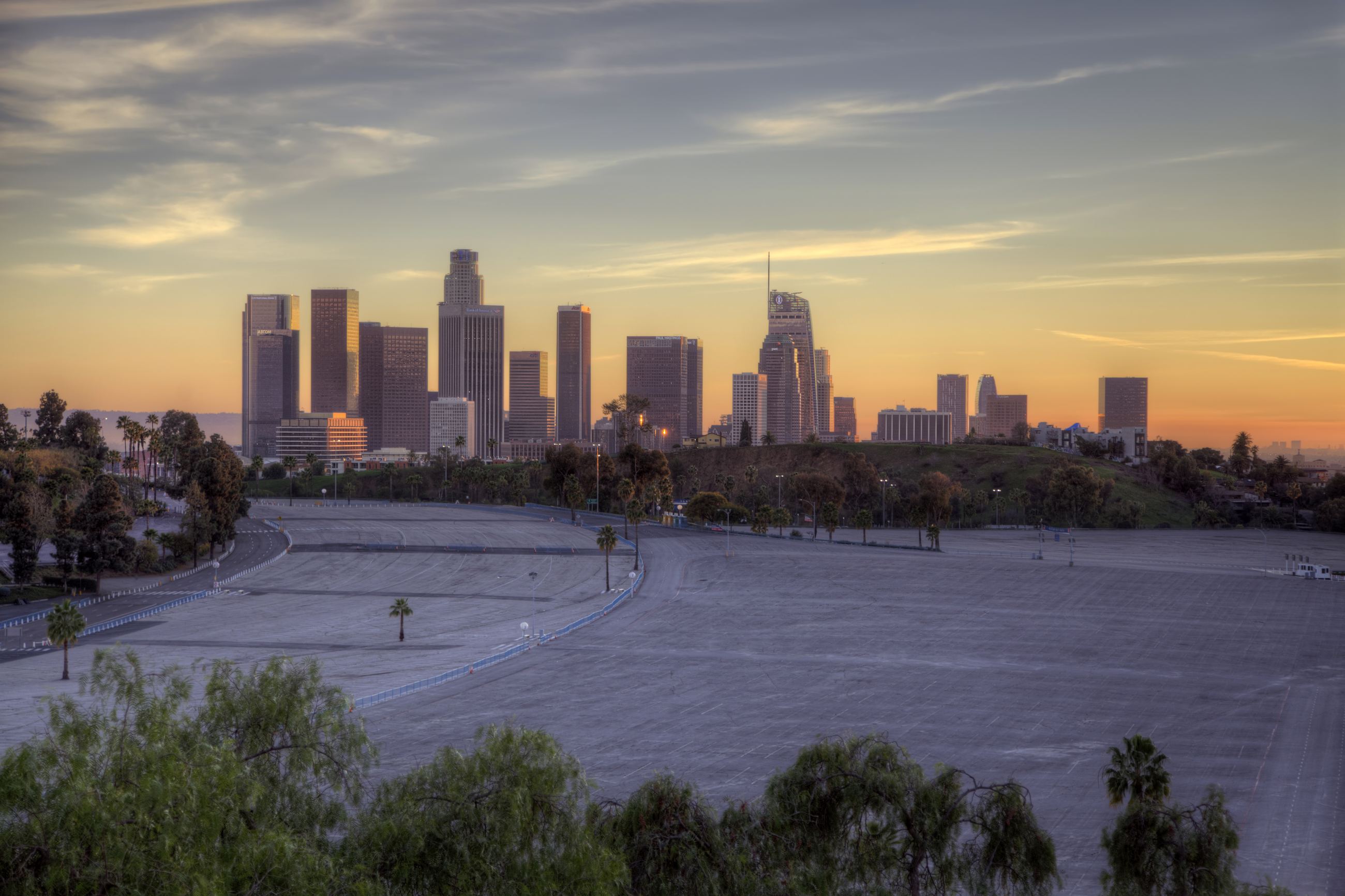 The Downtown skyline at sunset, seen across an empty stadium parking lot