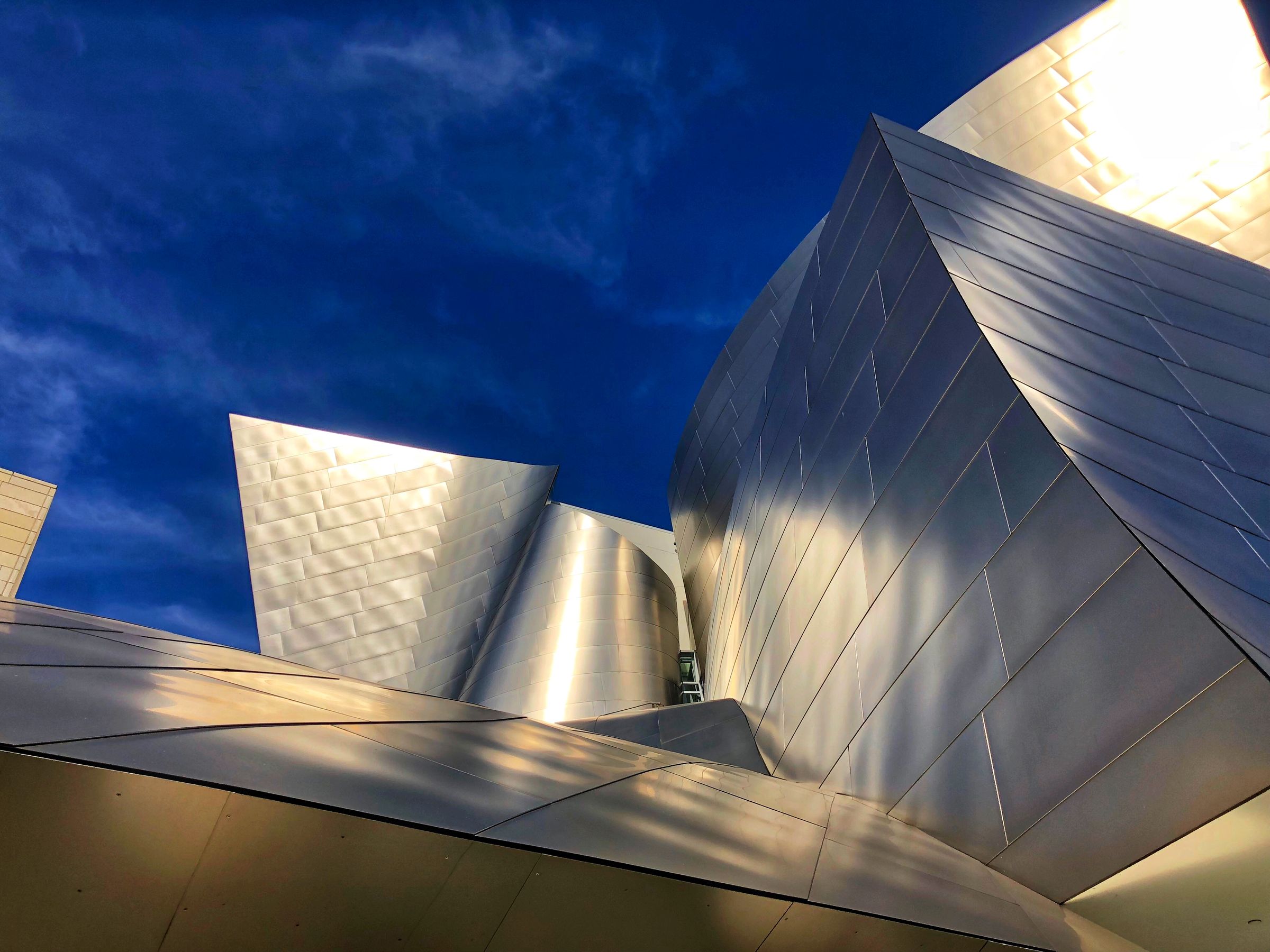 Brushed steel curves catching the last light against a deep blue sky