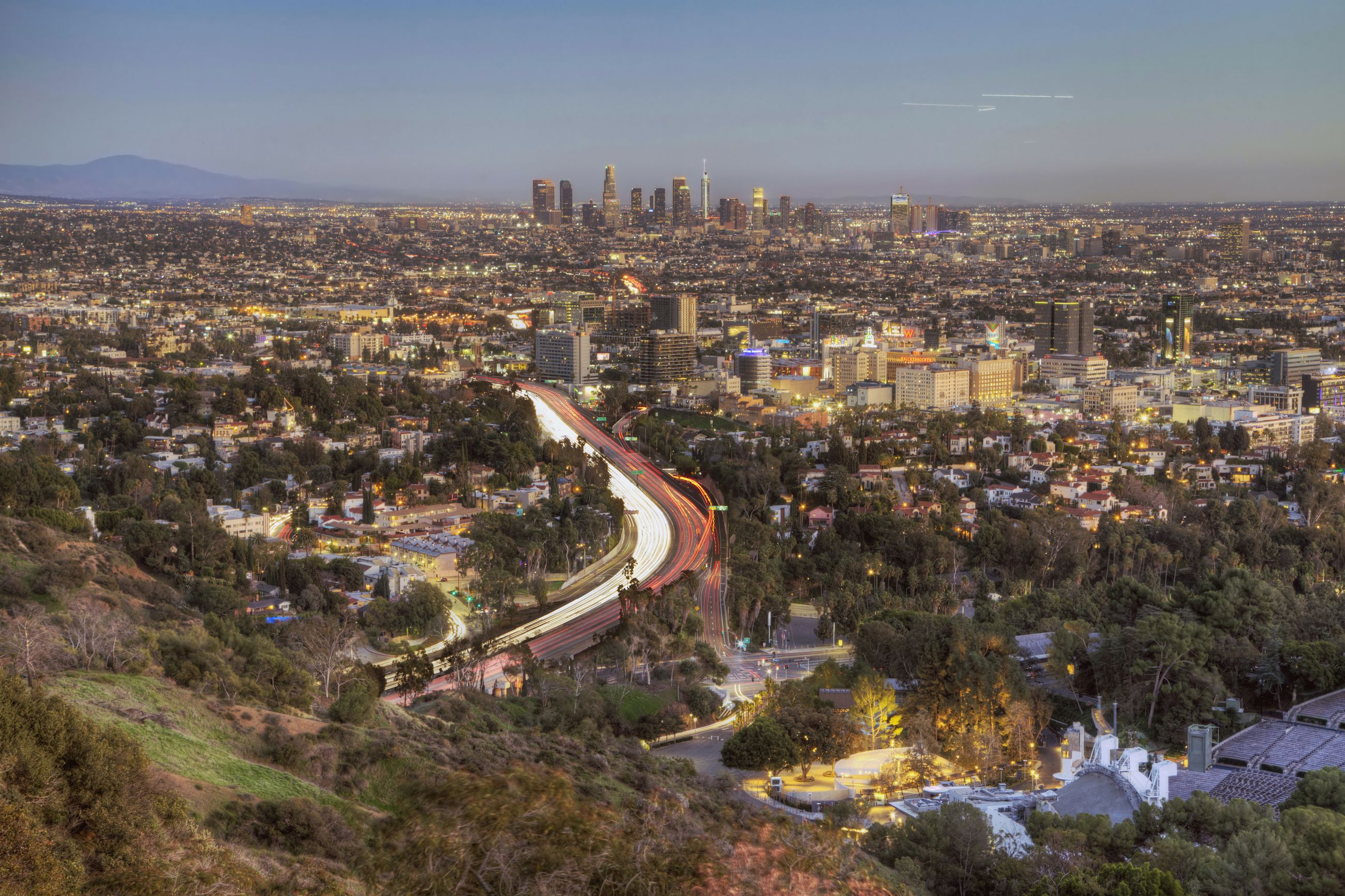 Light trails on the Hollywood Freeway at dusk, with Downtown Los Angeles on the horizon